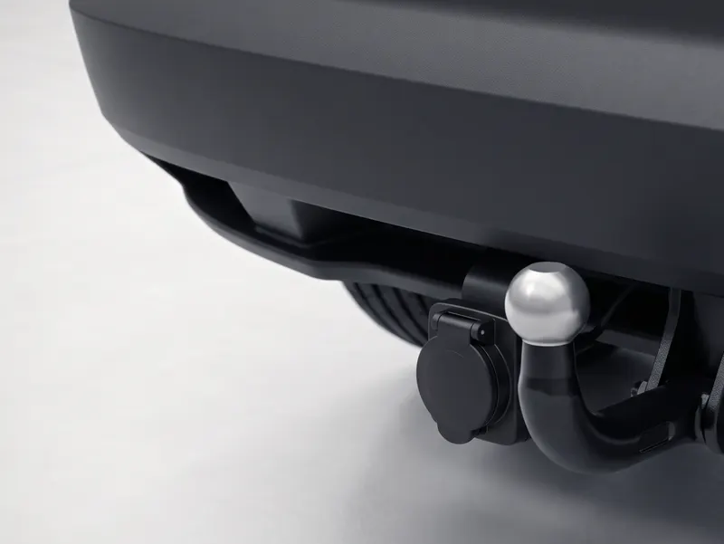 Nachgerüstete Anhängerkupplung mit Steckdose am Heck eines dunklen Autos